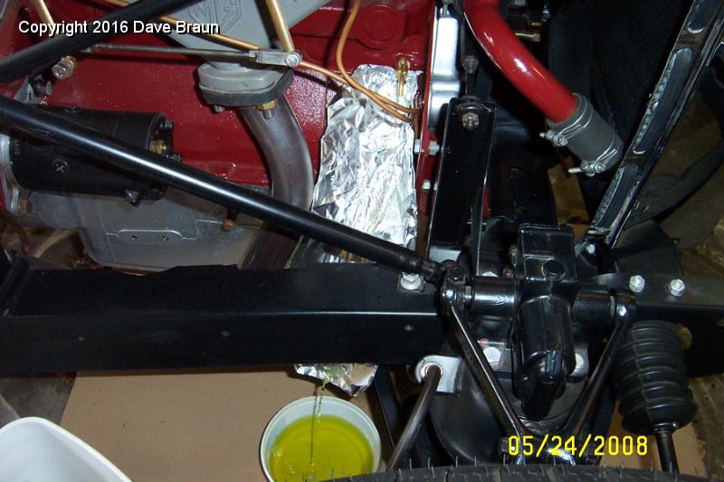 Draining block.jpg - The aluminum foil is there to keep the coolent from marring the paint on the block while it was dripping. It also served as a good funnel to drain the block. The block held approximately three of these tubs (Cool Whip, the Yanks will understand) each 3/4 full.