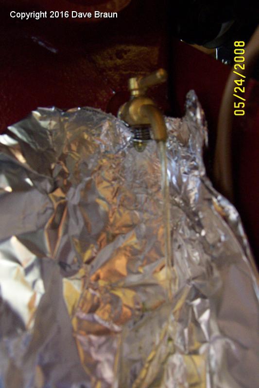 While draining can also see failure mode.jpg - A closer view of the drain, and the drip ready to fall from the spring, washer and cotter end of the drain cock. That's where it was dripping.