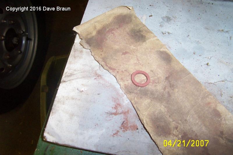 sanding gasket so drain orients.jpg - Some 220 grit sandpaper to take the washer down. Took about ten fittings to get it right. Seems I took off about 30 degrees of rotation at a time. I hope the fiber washer is still thick enough to do its job. It never occured to me to add some teflon tape to help the situation. Oh well, something to consider if I have a problem.