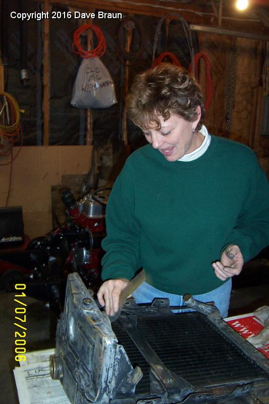 sanding the radiator 2.JPG - Diane sanding the radiator. She joined Laura at the Loft for a writing seminar, and then came over to help me with the TD. 80 grit followed by 400 grit. Seems odd, but it really worked well.