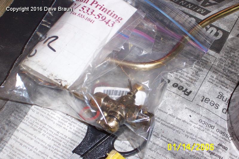 working on radiator tap ideas.JPG - Old drain with tubing. The replacement taps from Moss aren't correct. They expell fluid down, instead of straight back, and it isn't threaded, so the tube doesn't fit. I had an idea for putting a new handle on this drain. The spring for it flew across the room never to be seen again. Lew Palmer says there is a source for an original style tap in Great Britan.