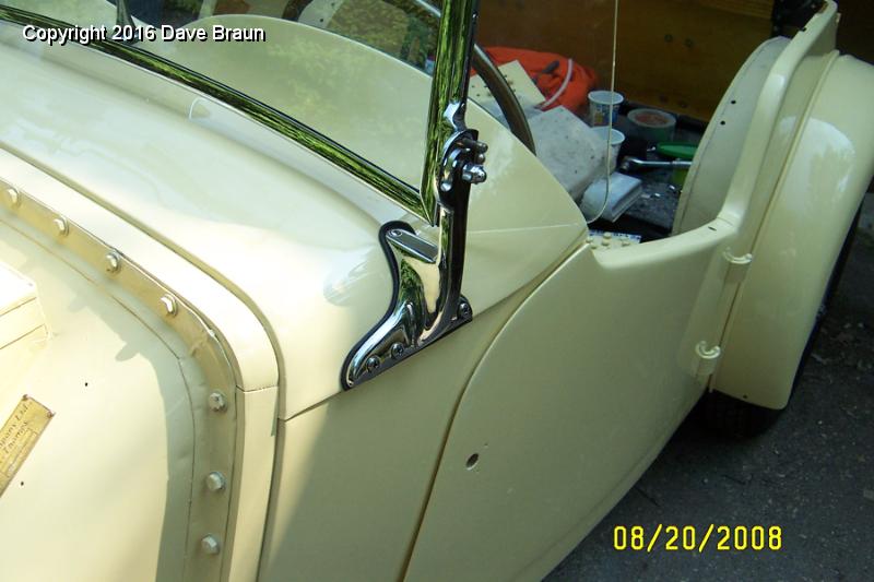Windscreen in place.jpg - The windscreen amd mirror are installed and only need final alignment and tightening of fasteners. The Seabrook wood is thick, and wasn't properly shaped by Brian to allow the Moss windscreen screws to fit even after drilling the holes straight. We substituted 1/2 inch longer stainless steel with polished heads. At least the heads will be flush and even with the stanchions.