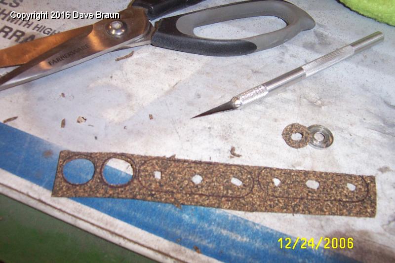 cutting wiper motor mounting gaskets.jpg - Cutting the rubberized cork gaskets. Correct gaskets came with the mounting hardware kit from Moss, but I had all the mounting hardware. I was hoping for a new phenolic block. I can't believe they asked so much for the kit, I'm sending it back. Mark says I'm not the first person to react that way to the mounting kit.